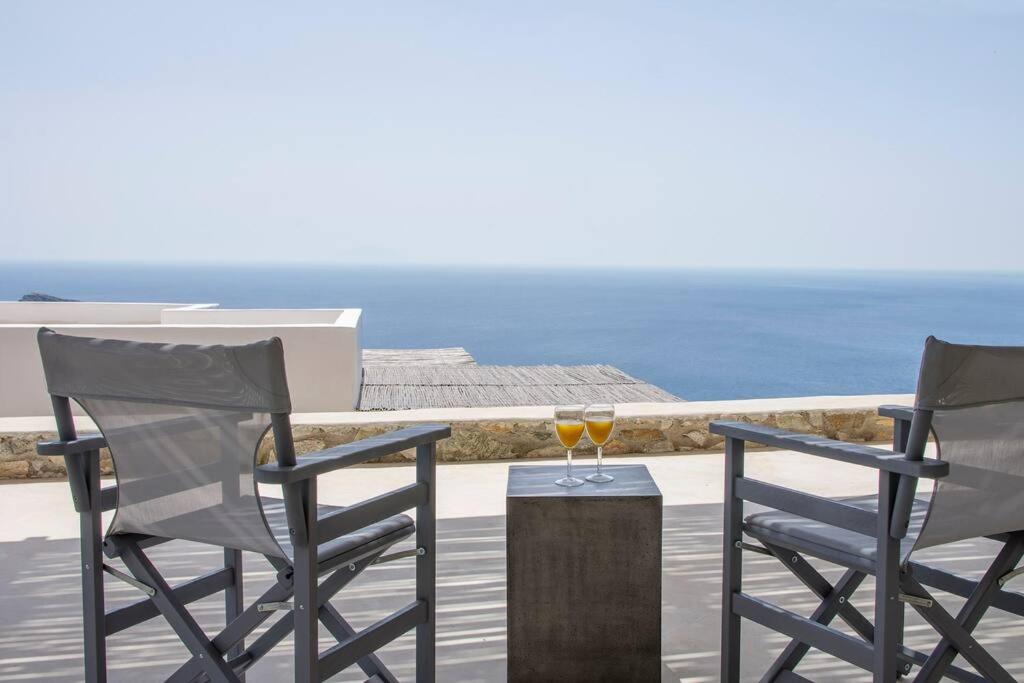 two chairs and a table with two glasses of wine at Dreamy Cycladic Summer House 3 in Serifos Chora