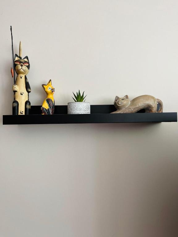 a black shelf with figurines on a wall at Le Georges V in Alzonne