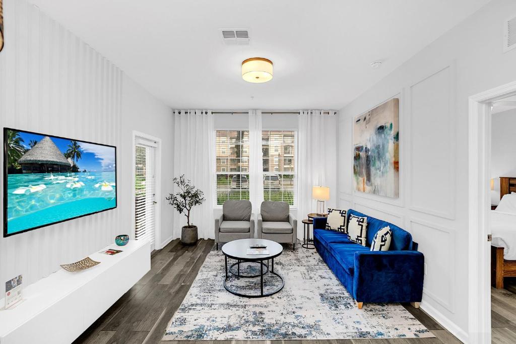 uma sala de estar com um sofá azul e uma mesa em Ground-floor condo next to Vista Cay Clubhouse and pool! em Orlando