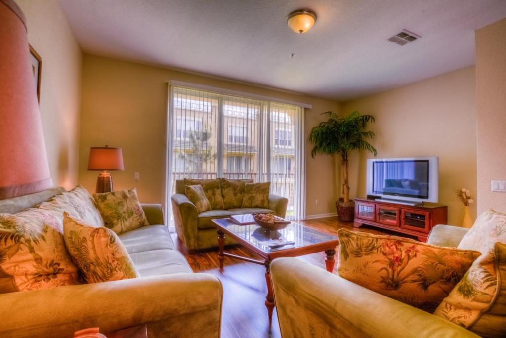 a living room with two couches and a tv at Resort Townhome: Perfect Orlando Vacation Spot in Orlando