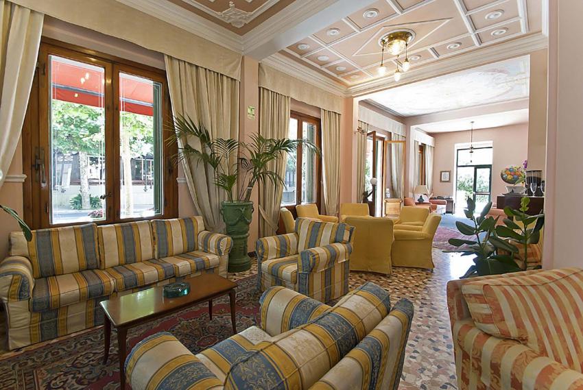 モンテカティーニ・テルメにあるHotel Maestosoのソファと椅子付きの広いリビングルーム