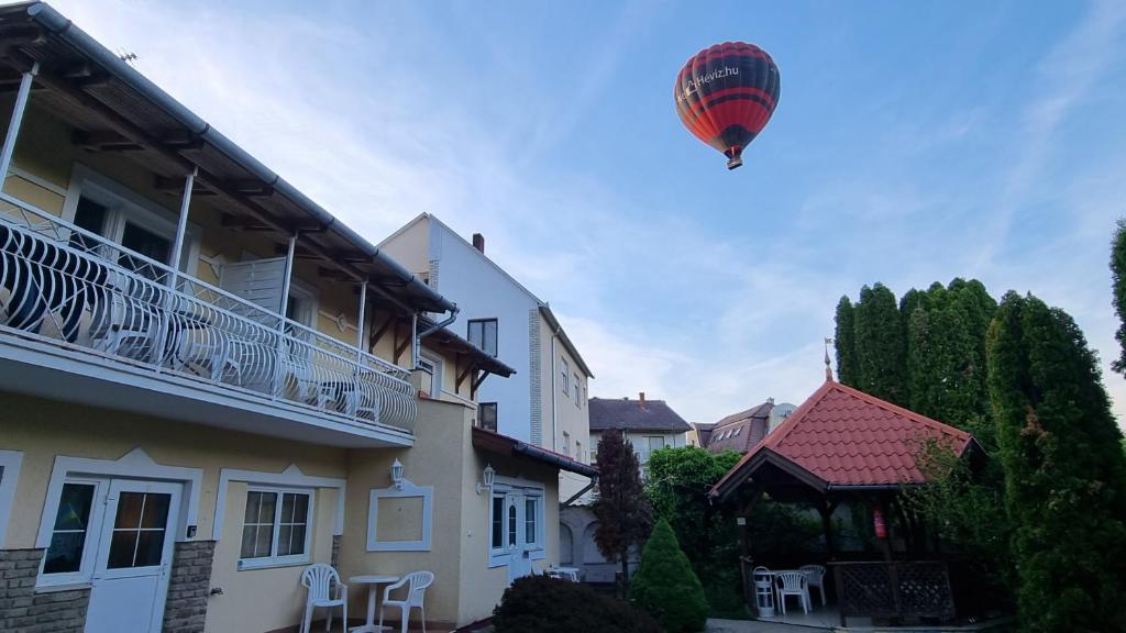 een heteluchtballon die over een huis vliegt bij Magic Garten in Hévíz