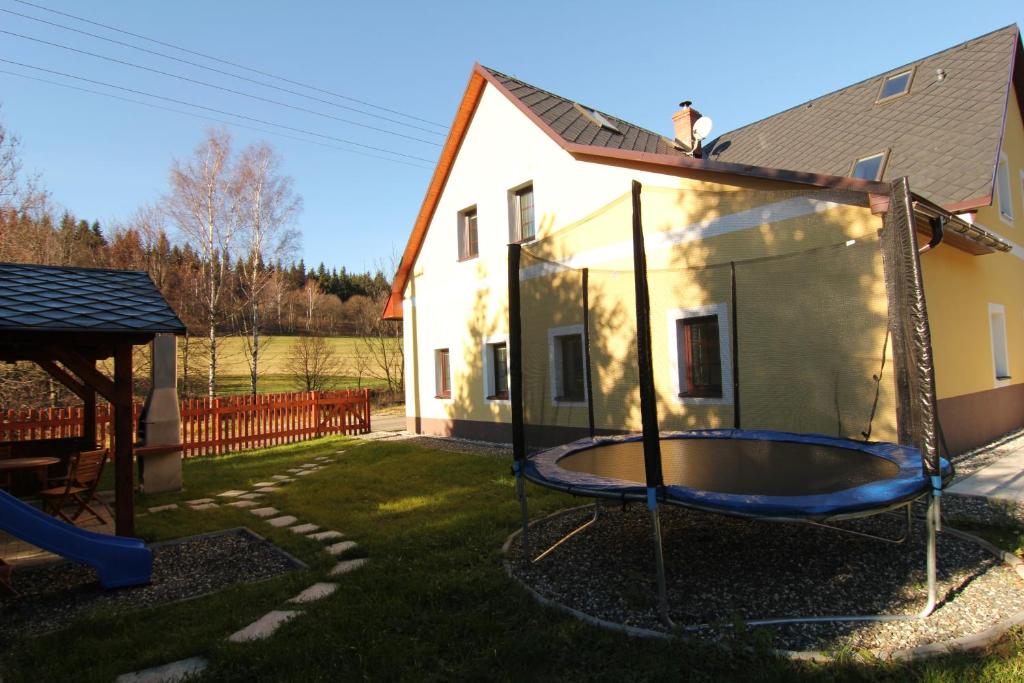 a backyard with a trampoline in front of a house at Apartment Ostružná in Ostružná