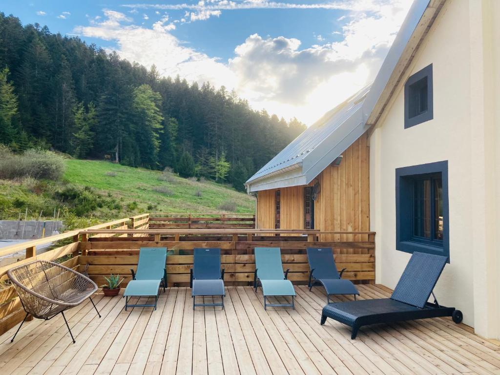 een terras met stoelen en een tafel op een gebouw bij Le grand Valtin, 800m d altitude pleine nature 12 pers in Ban-sur-Meurthe-Clefcy