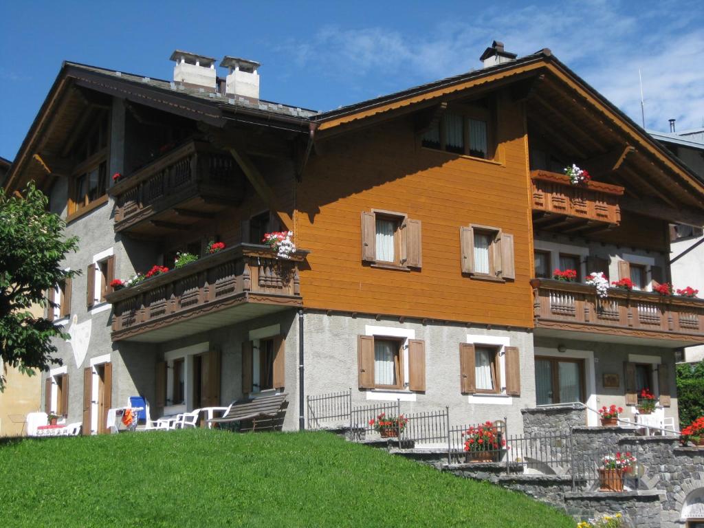 a large building with balconies and flowers on it at Baita al Pian in Bormio