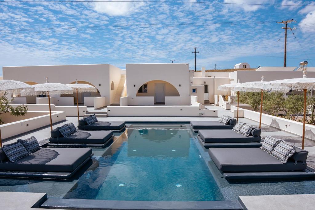 カルテラドスにあるZaitun Luxury Suitesのリゾート内のプール(ラウンジチェア、パラソル付)