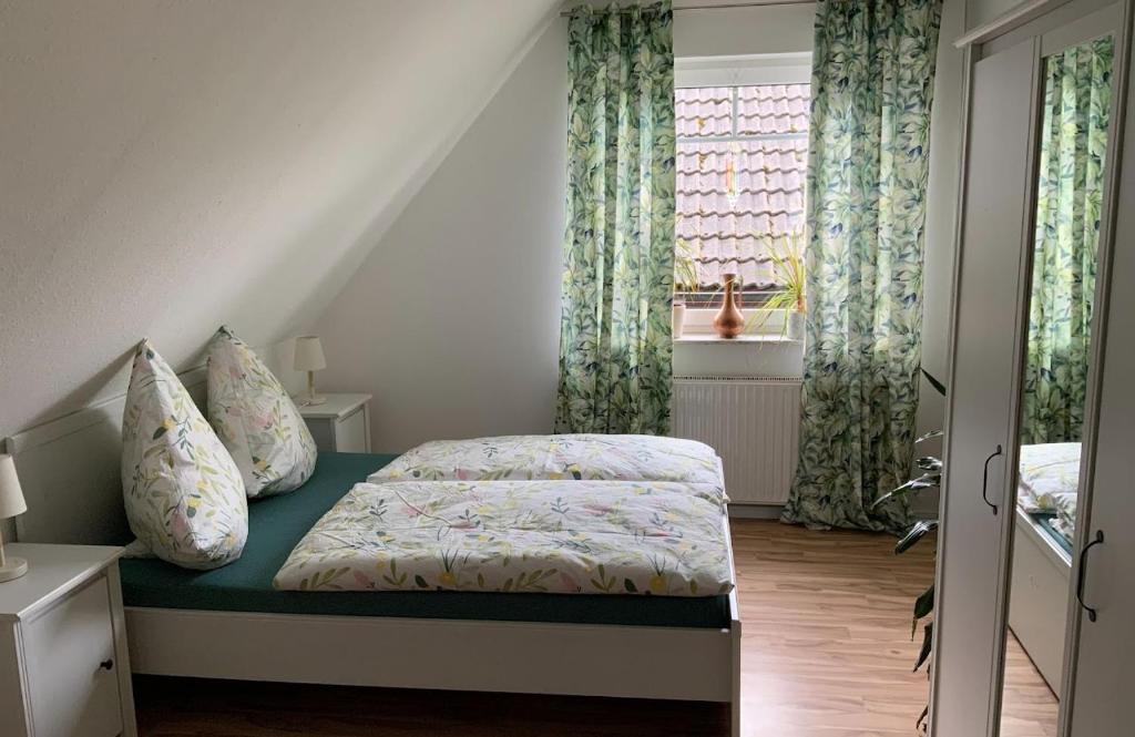 a small bedroom with a bed and a window at Ferienwohnung Halen Landkreis Cloppenburg 