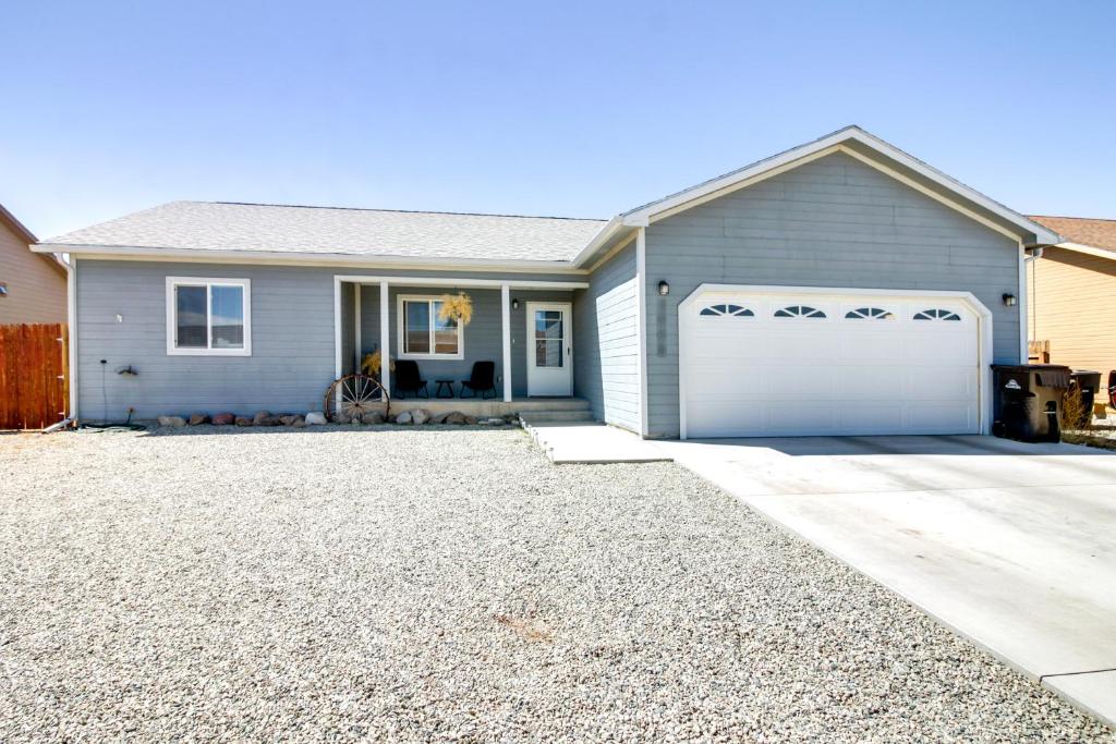 a gray house with a white garage at Cozy Colorado Retreat with Patio, Grill and Fire Pit! in Alamosa