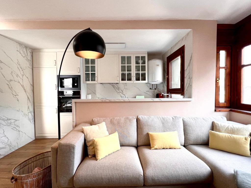 a living room with a couch and a kitchen at Dúplex La Roca in Espot