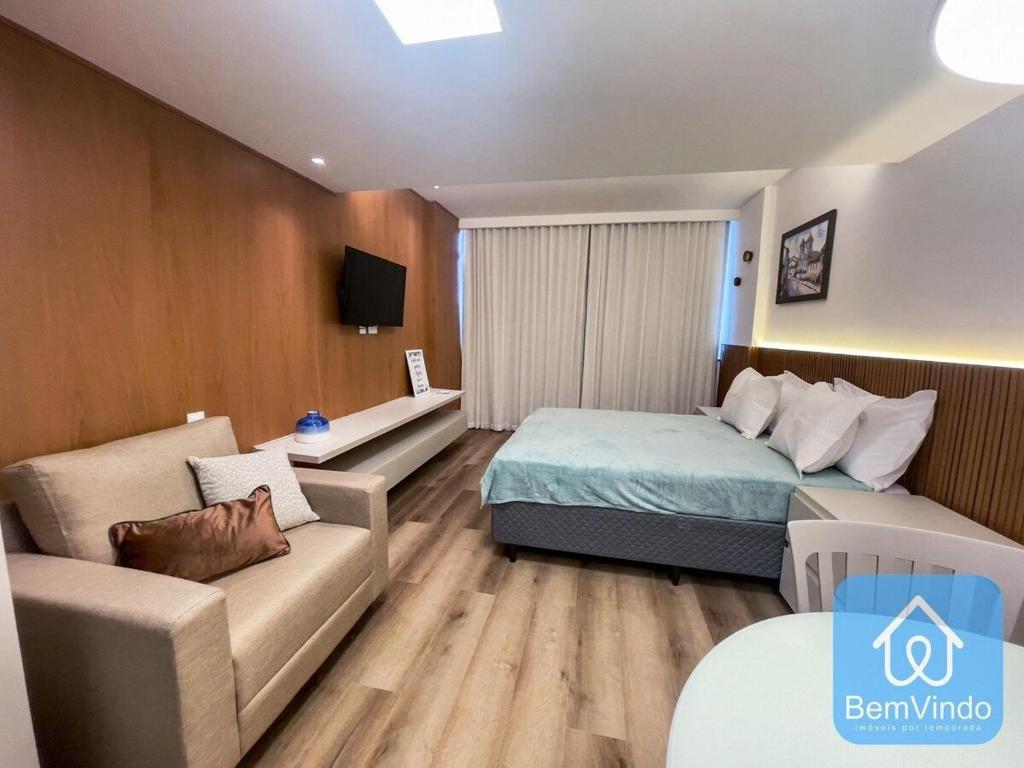 um quarto de hotel com uma cama e um sofá em Apartamento completo com píer e acesso ao mar 4 em Salvador