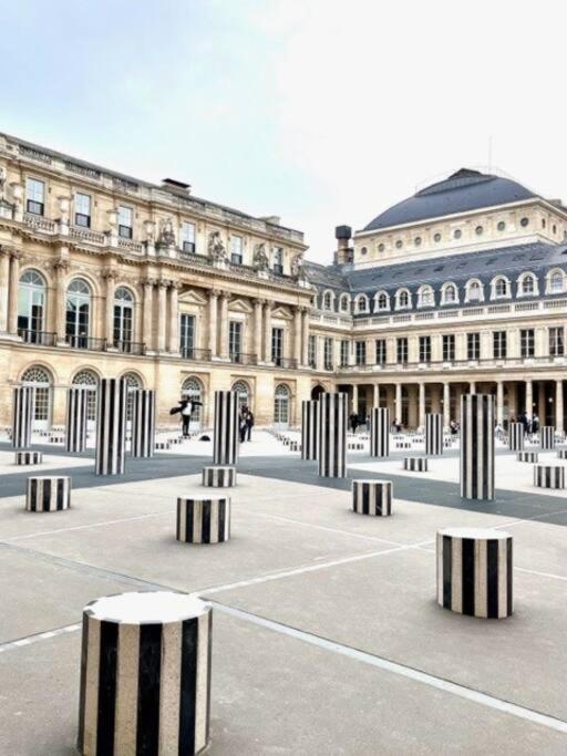 un grand bâtiment avec des colonnes noires et blanches dans une cour dans l&#39;établissement ENJOY PARIS, à Paris