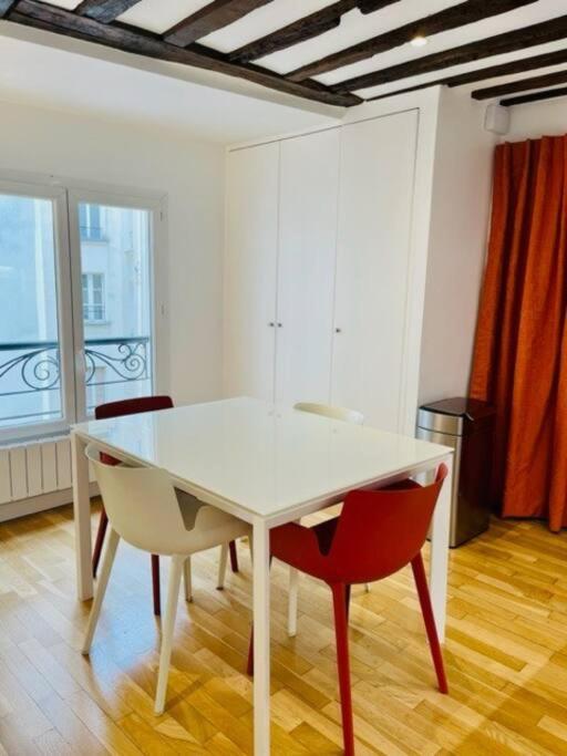 - une table et des chaises blanches dans la chambre dans l&#39;établissement ENJOY PARIS, à Paris