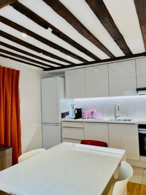 une cuisine avec des placards blancs et un comptoir blanc dans l&#39;établissement ENJOY PARIS, à Paris