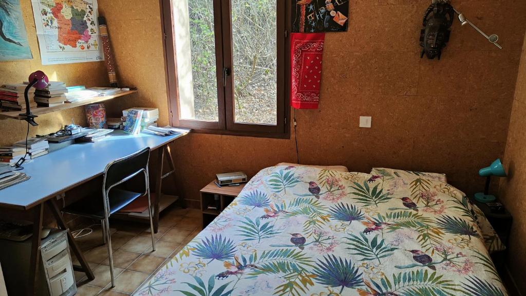 1 dormitorio con 1 cama y escritorio con escritorio en Chambre dans villa, en Chaffaut-Lagremuse