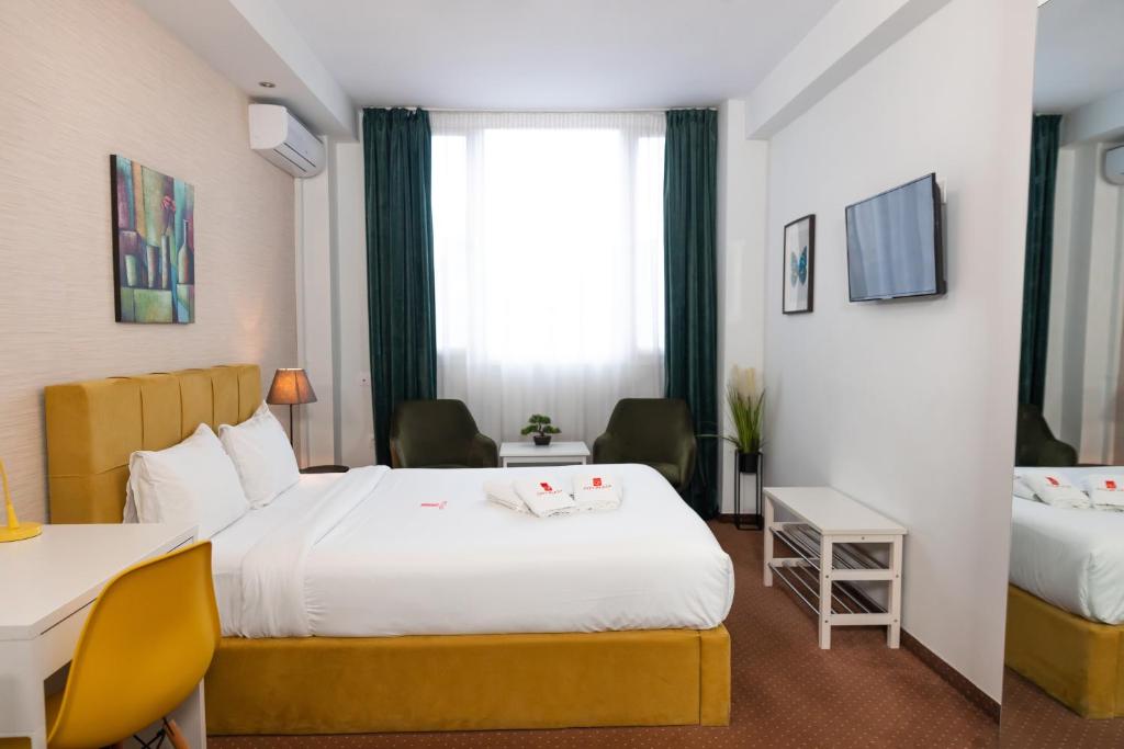 een hotelkamer met 2 bedden en een raam bij City Plaza Apartments & Rooms in Thessaloniki