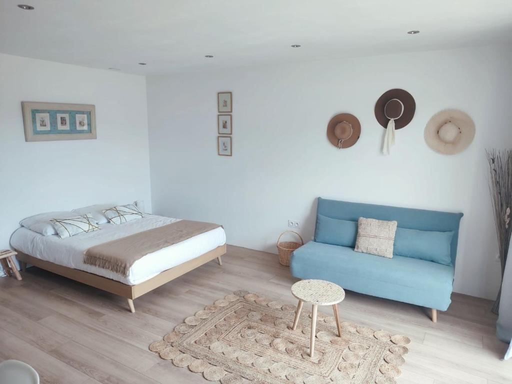 une chambre avec un lit et un canapé bleu dans l'établissement Le Vendalivet, à Vendays-Montalivet