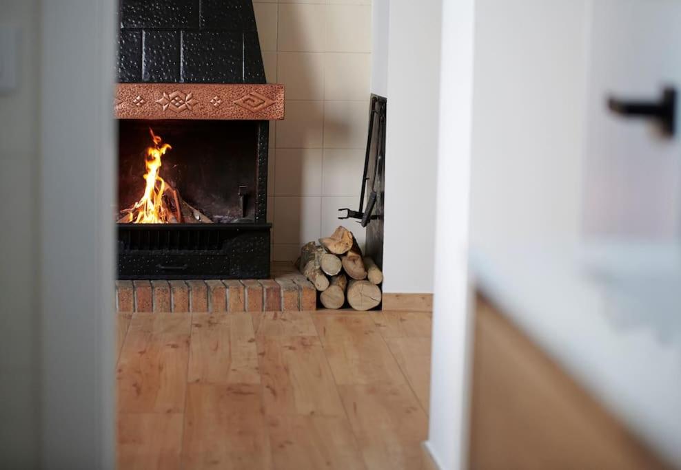 a fireplace in a living room with a fire at Can Mosqueroles casa en Castellfollit de la Roca in Girona