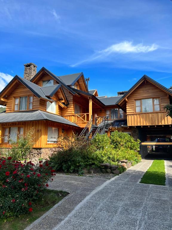 una casa in legno con un sentiero di fronte di Apartamentos céntricos en San Martin de los Andes. a San Martín de los Andes