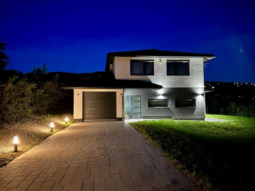 a white house with a garage at night at Luxury Villa Rosemary with free garage in Szentendre in Szentendre