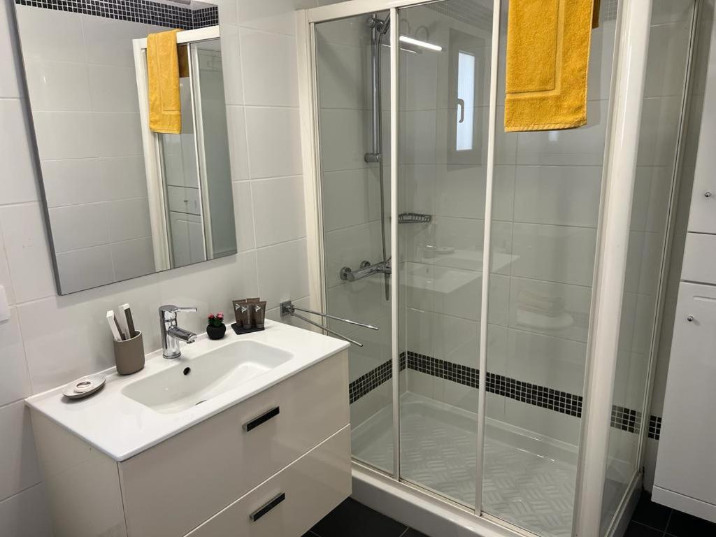 a white bathroom with a shower and a sink at Tender Suite in Corralejo