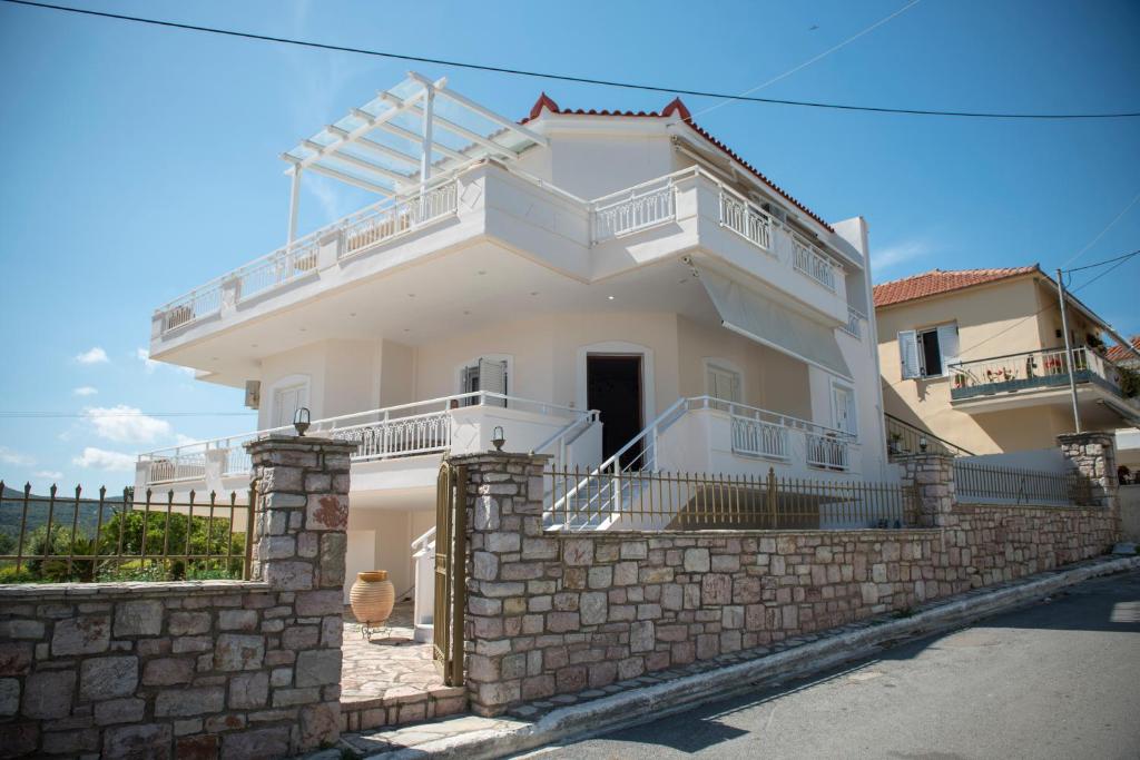 a large white house with a stone wall at Villa Maria in Armenoí