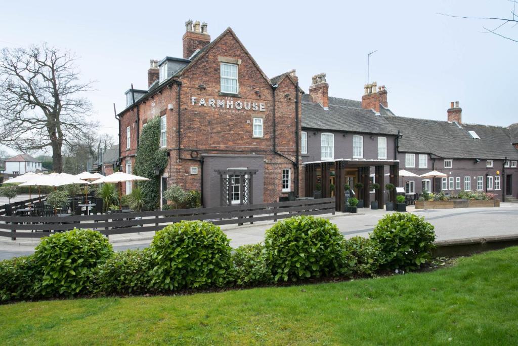 a large brick building with benches in front of it at The Farmhouse in Derby