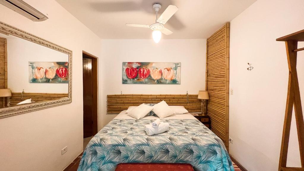 a bedroom with a bed and a ceiling fan at Villa Adria in Ilhabela