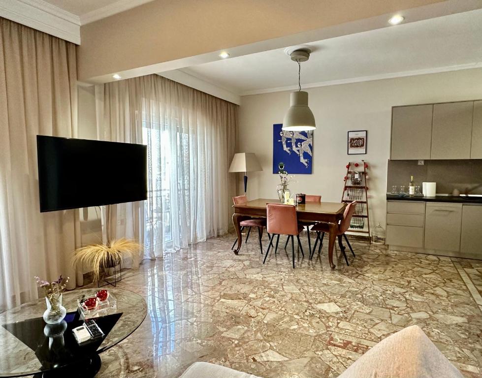 sala de estar con mesa y cocina en Noema Urban Apartment, en Kavala