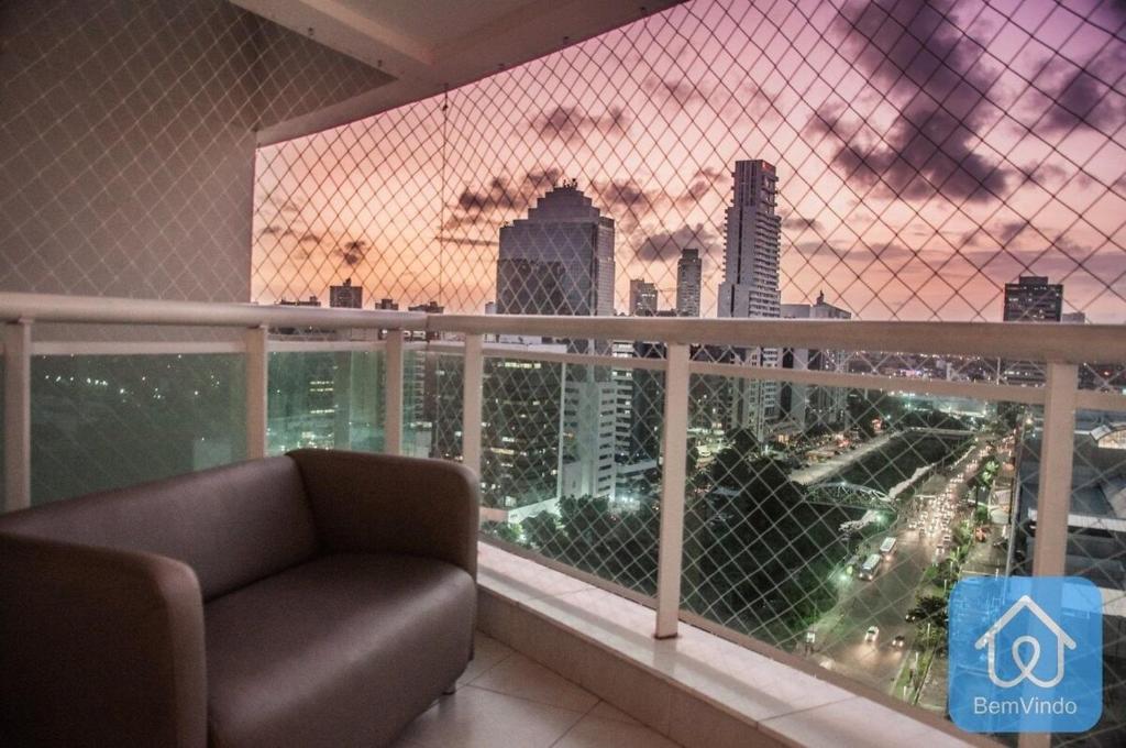 un divano su un balcone con vista sulla città di Apartamento completo ao lado do Salvador Shopping a Salvador