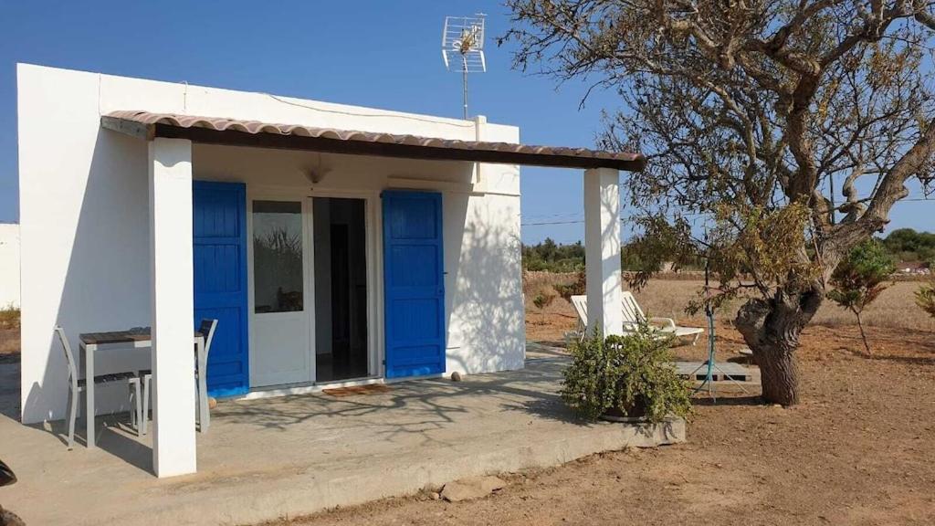 a small house with blue doors in the desert at CASA PATY, Estudio rural. Sant Ferran FORMENTERA in San Ferrán de ses Roques