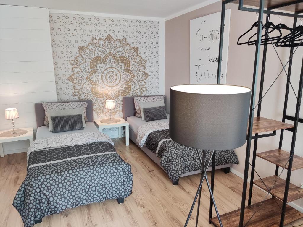 Eisingen的住宿－Apartment for family & friends，客房设有两张床、椅子和桌子。