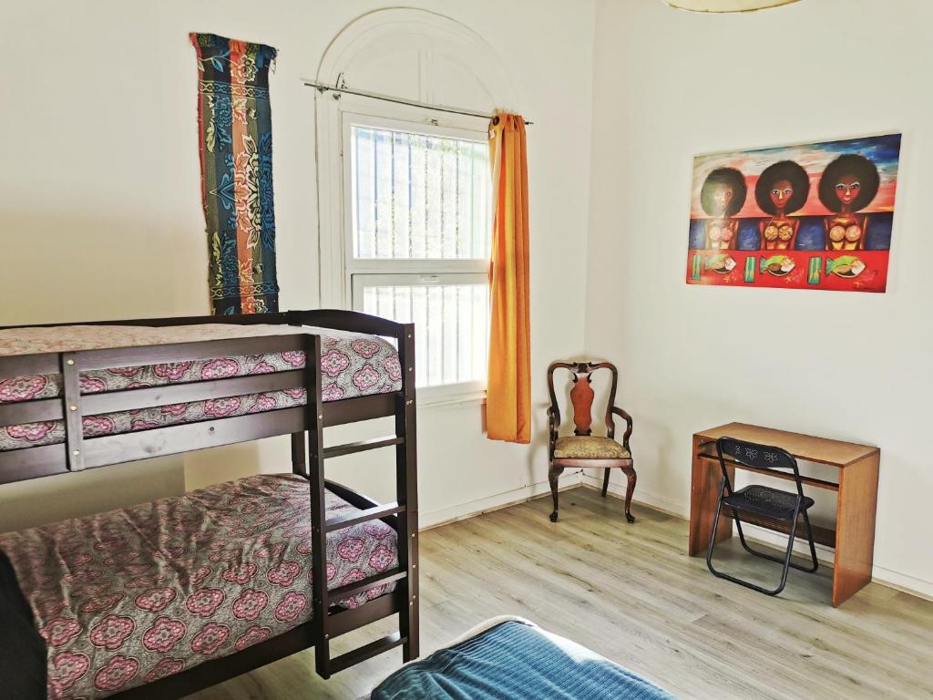 a bedroom with a bunk bed and a chair at La Casa Piola in Valparaíso