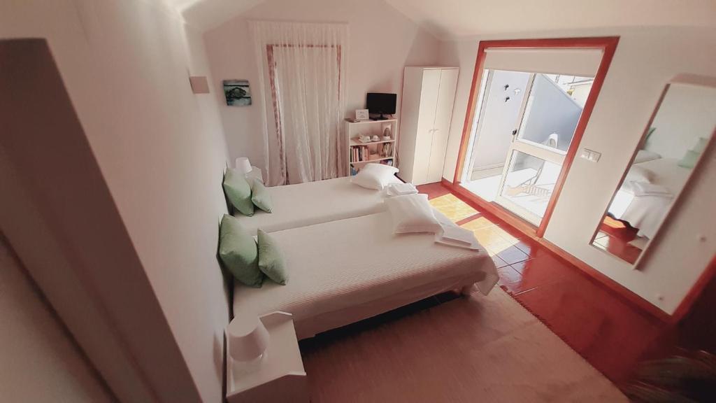a living room with a white couch and a mirror at SUN & SAND GUESTHOUSE in Esposende