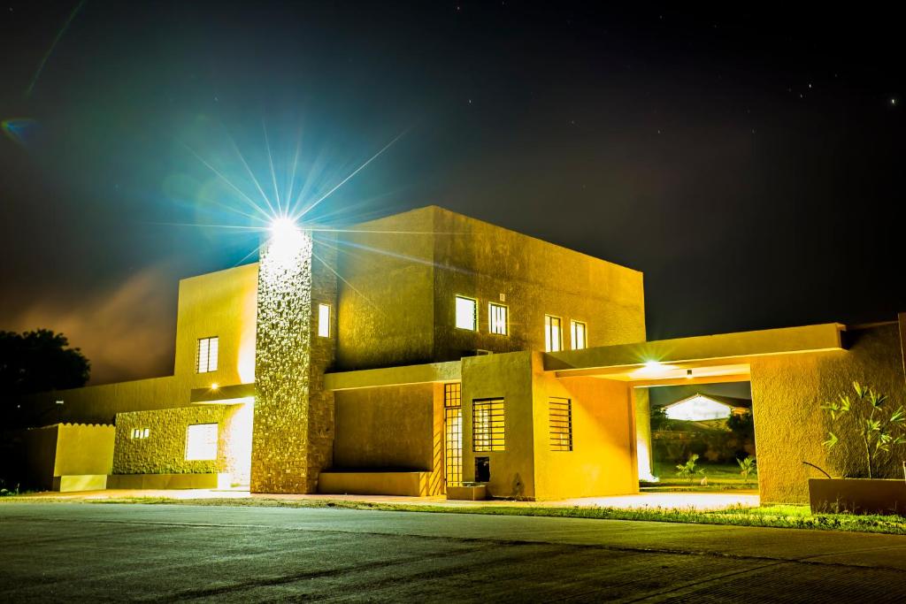 un edificio con una luce sopra di esso di notte di El Suto Apart Hotel a San José de Chiquitos