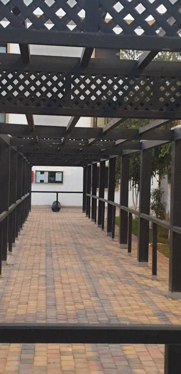 a wooden pergola with a table on a patio at SALICORNE 1 marina saidia appt in Saïdia