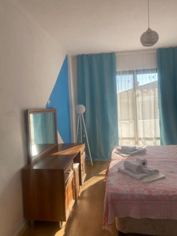 a bedroom with a bed and a dresser and a mirror at Deniz Kızı Otel Çeşme in Çeşme