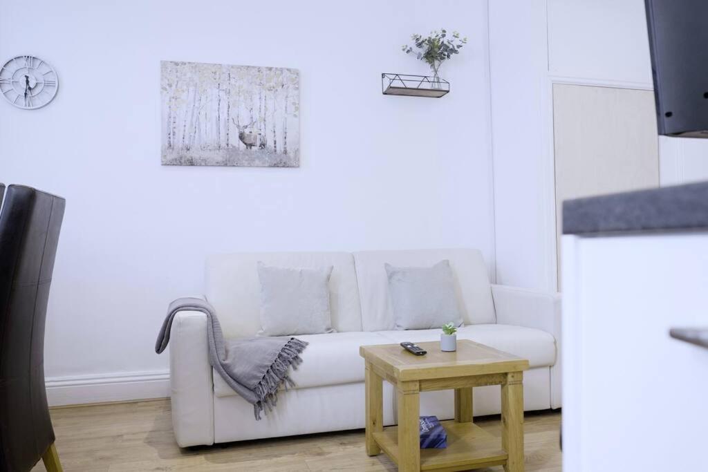 a living room with a white couch and a table at Apartment in West Yorkshire 3 in Keighley