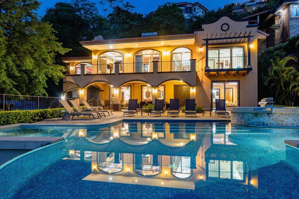una casa grande con piscina frente a ella en Casa Ilan Ilan en Playa Hermosa