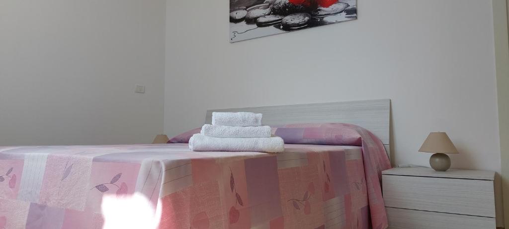 1 dormitorio con 1 cama con manta rosa y blanca en Lovely House risveglio fronte mare en Marina di Pescoluse