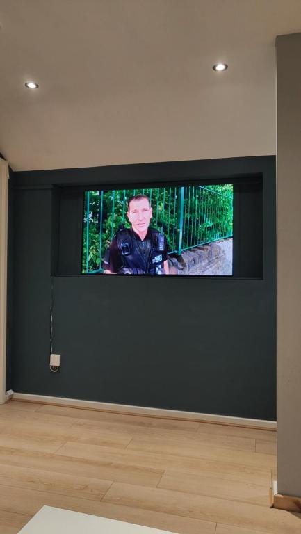 een flatscreen-tv op een zwarte muur in een kamer bij 1Mart Lane Burscough in Burscough