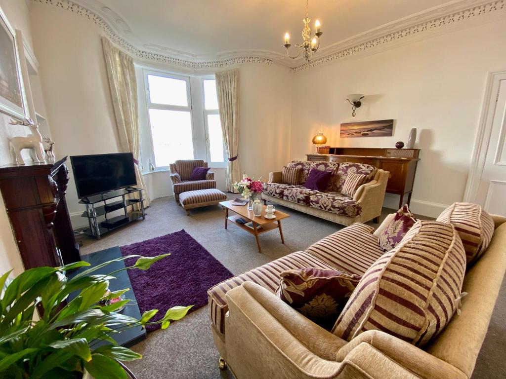 uma sala de estar com dois sofás e uma televisão em Dairsie Sea View em Rothesay