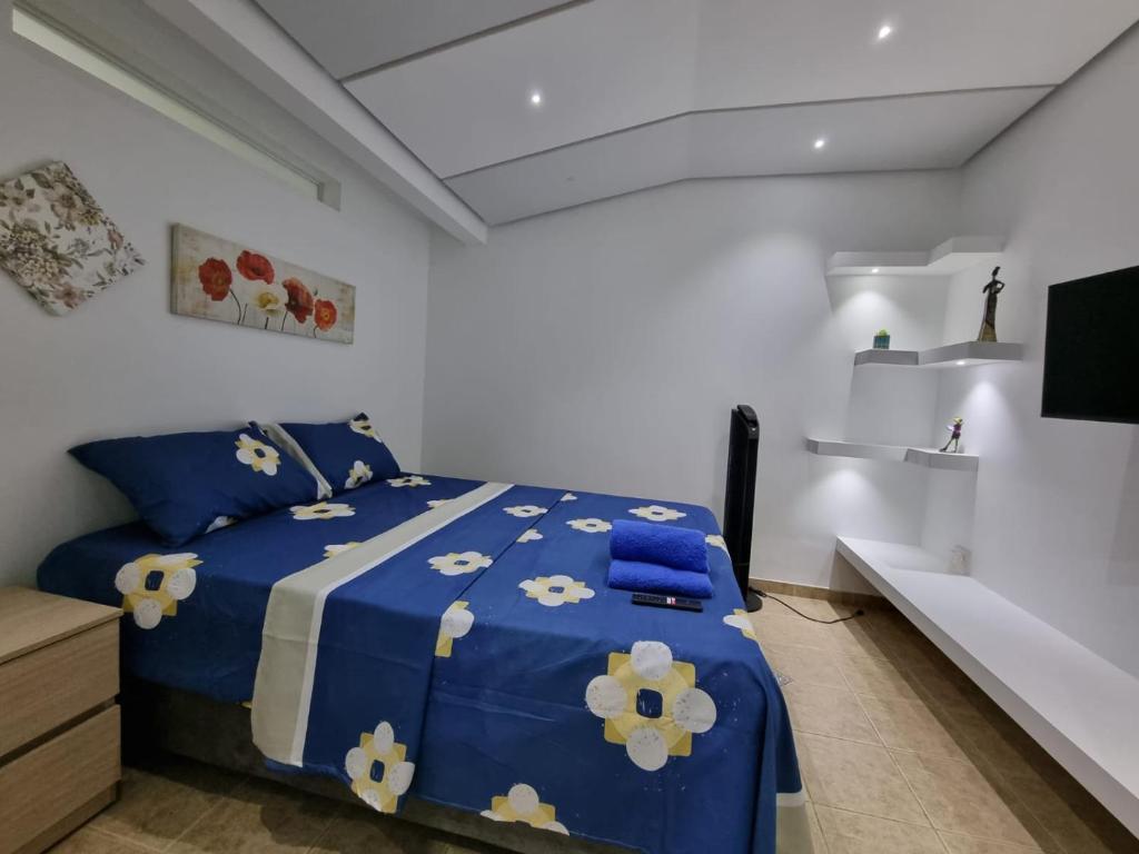a bedroom with a blue bed with blue and white sheets at Hospedaje Casa Leví in Cali