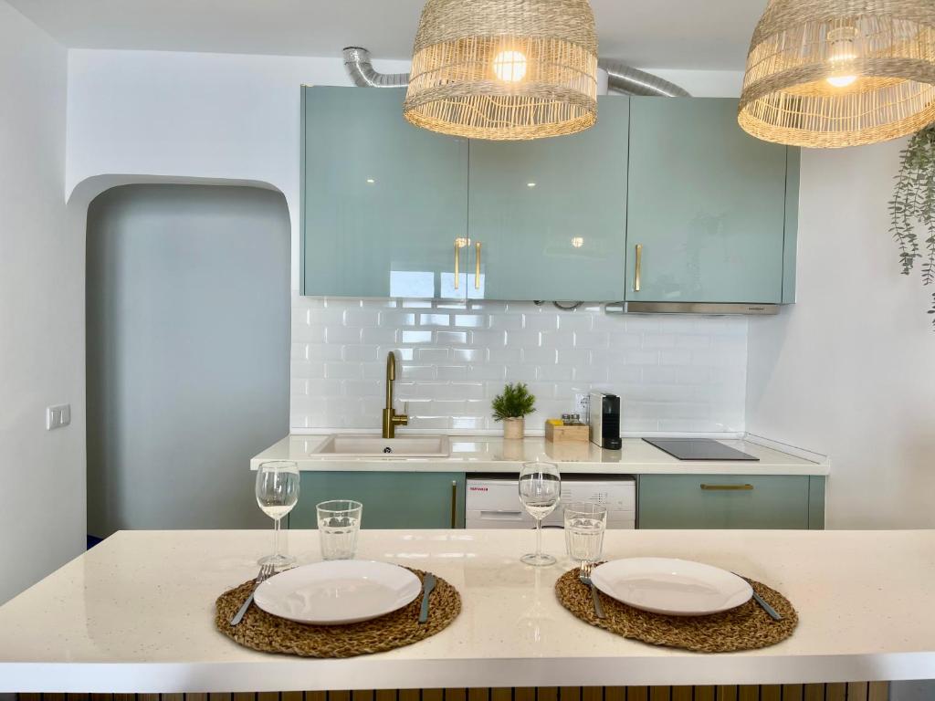 een keuken met twee borden en glazen op een tafel bij White Sand Apartments Downtown Albufeira in Albufeira