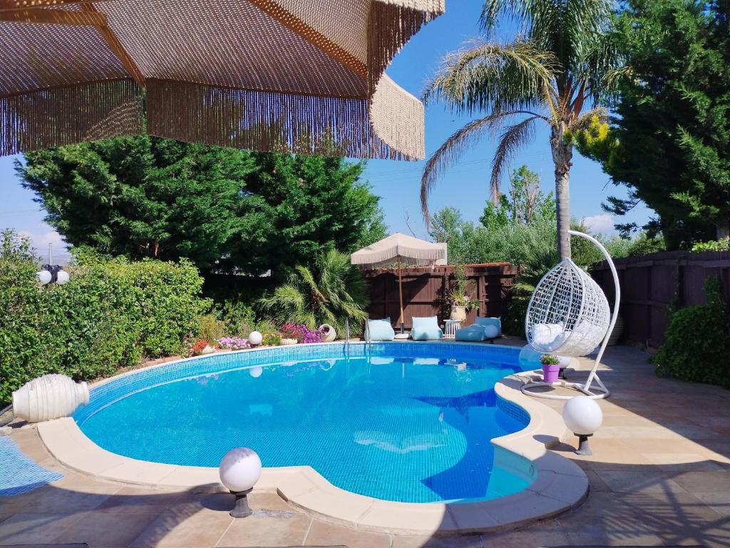 a swimming pool in a backyard with a palm tree at Luxury Villas Chrysa Private Pool & Spa in Nafplio