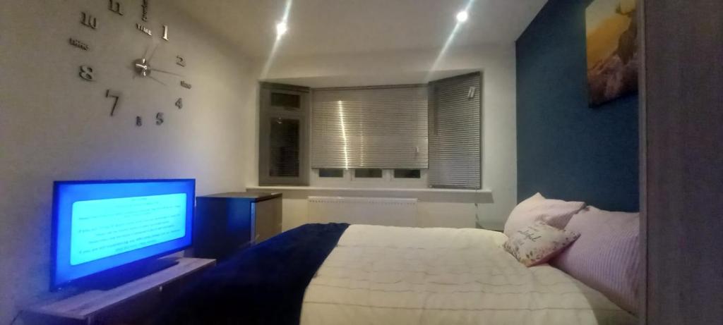 a bedroom with a bed and a computer monitor at Feel at Home in Elmers End