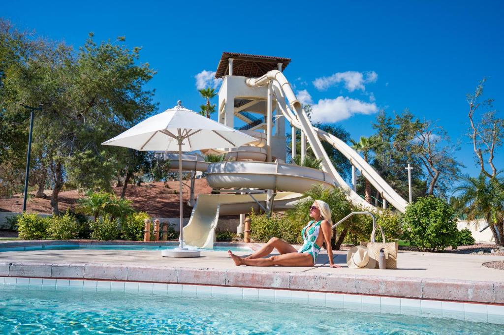 Eine Frau sitzt neben einer Wasserrutsche in der Unterkunft Arizona Grand Resort in Phoenix