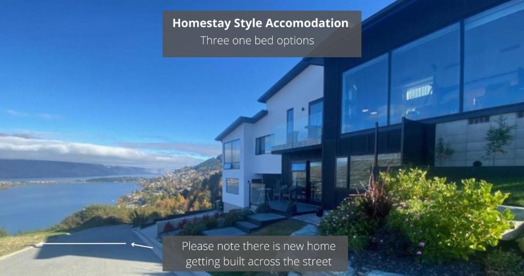 a building with a view of a body of water at Luckie Lane Homestay in Queenstown