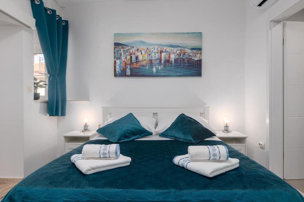 a bedroom with a blue bed with two pillows at Harmony Apartments in Split