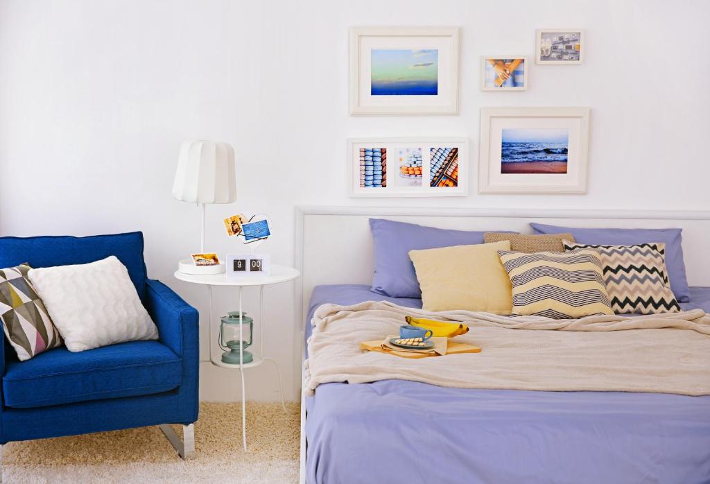 um quarto com uma cama e uma cadeira azul em Matera Like Home - rooms - Via del Corso em Matera