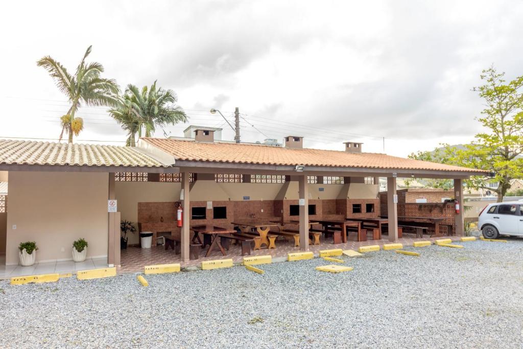 um edifício com uma mesa e cadeiras num parque de estacionamento em Tropical Itapema em Itapema